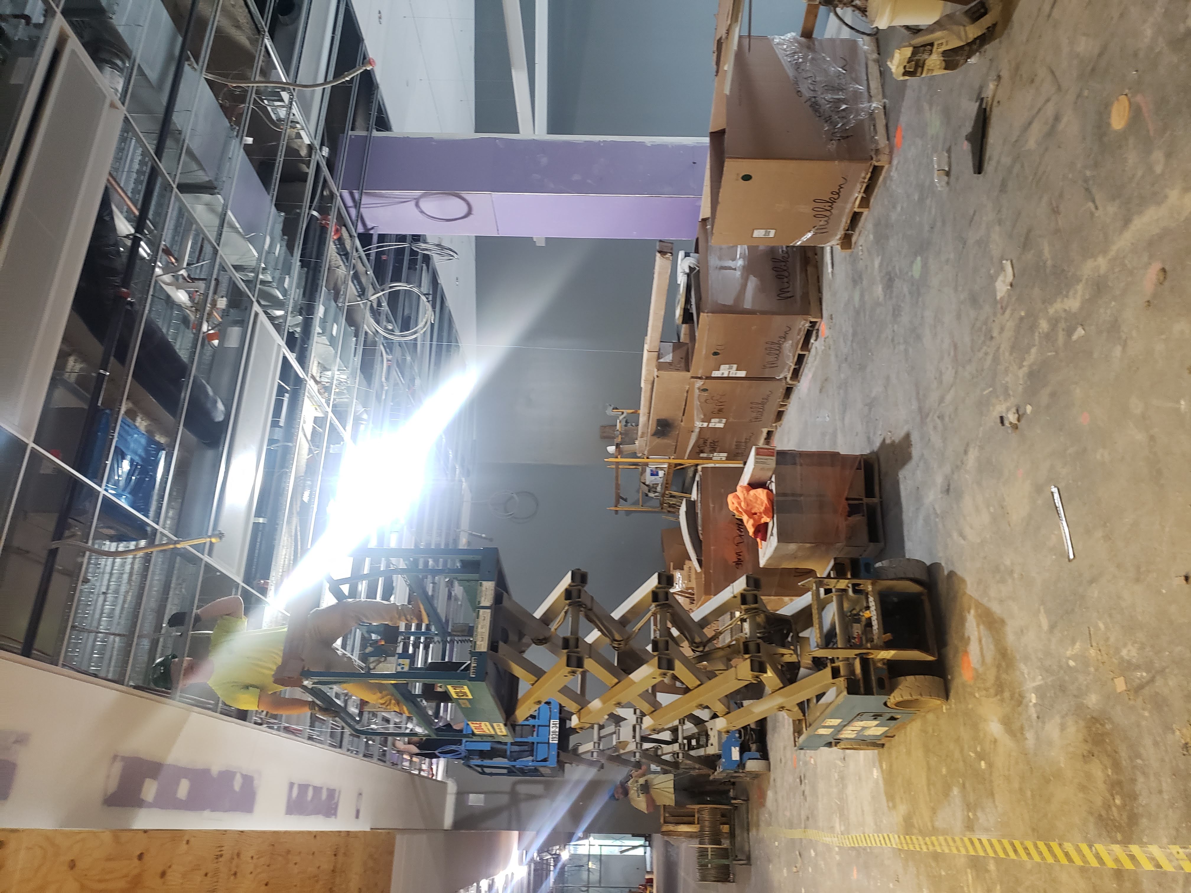 Open office fit-out scissor lift above ceiling grid