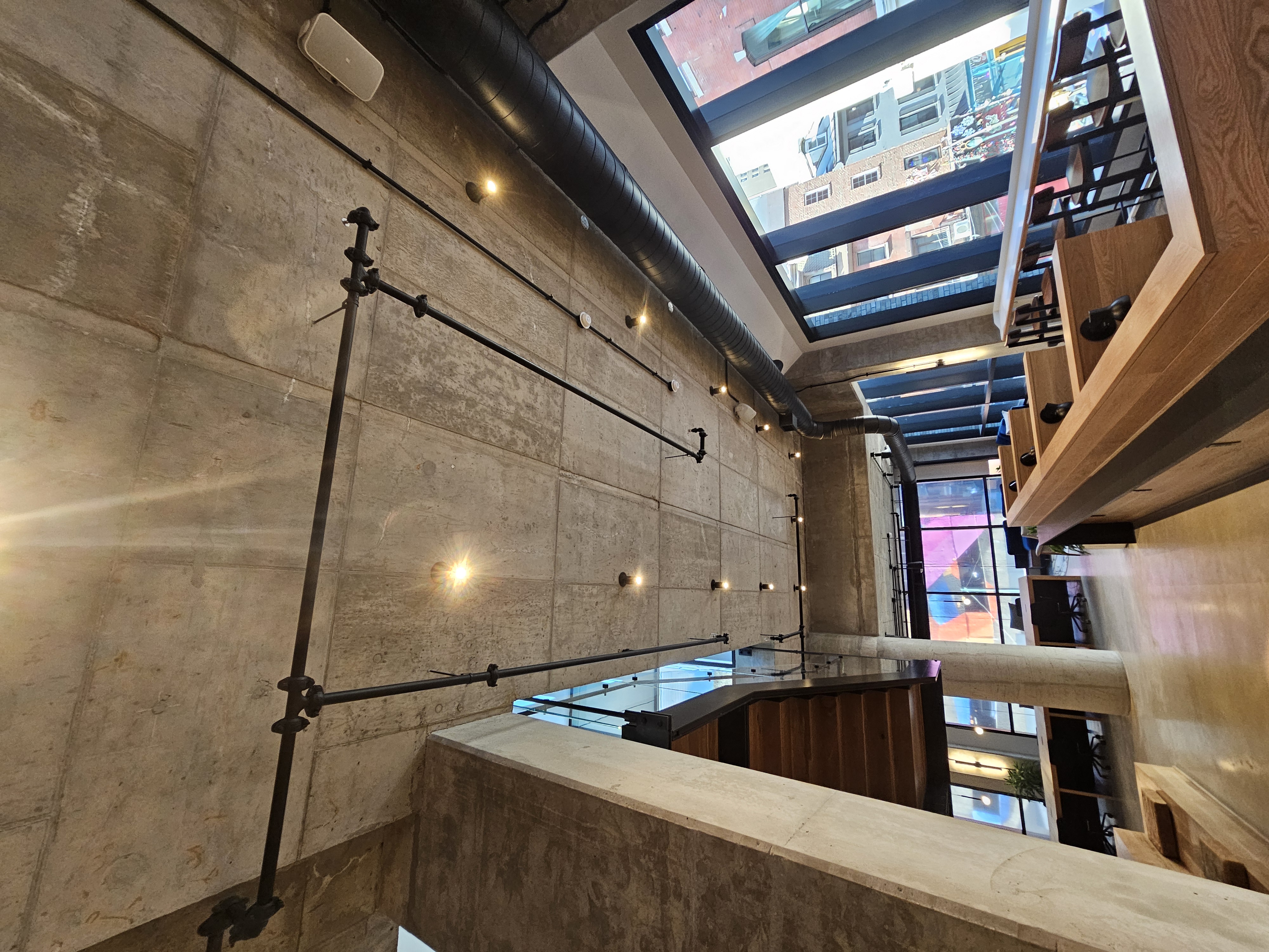 Exposed concrete ceiling with custom black conduit track system